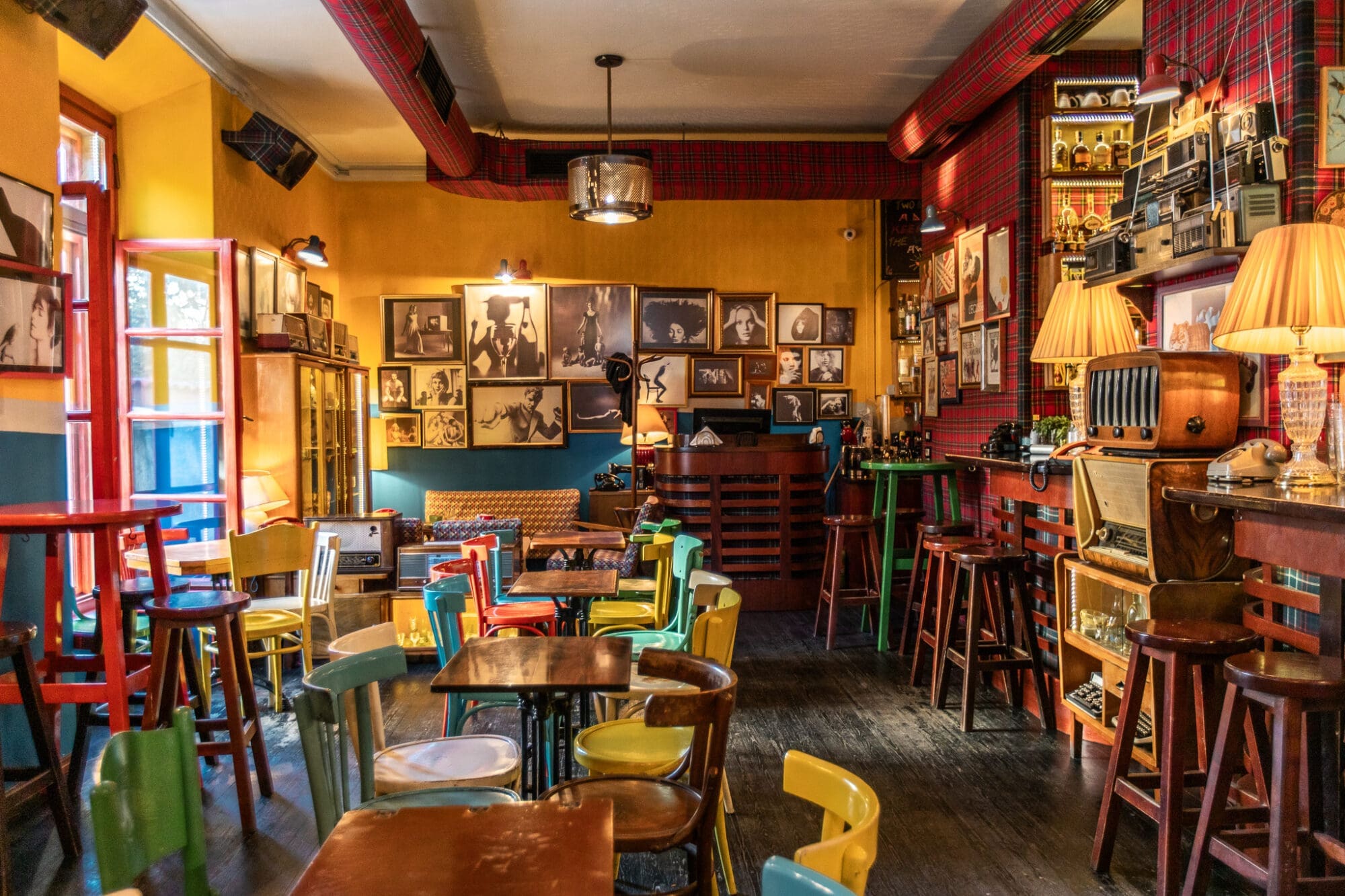 Quirky bar interior filled with coloured chairs and old radios in Tirana, Albania