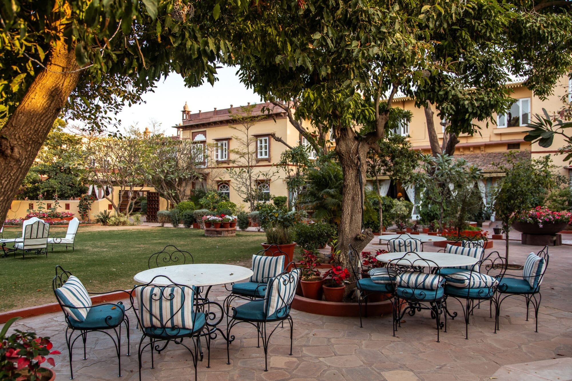 Exterior Courtyard filled with flowers and outdoor seating at Rohet Garh, a Luxury hotel in Rajasthan India