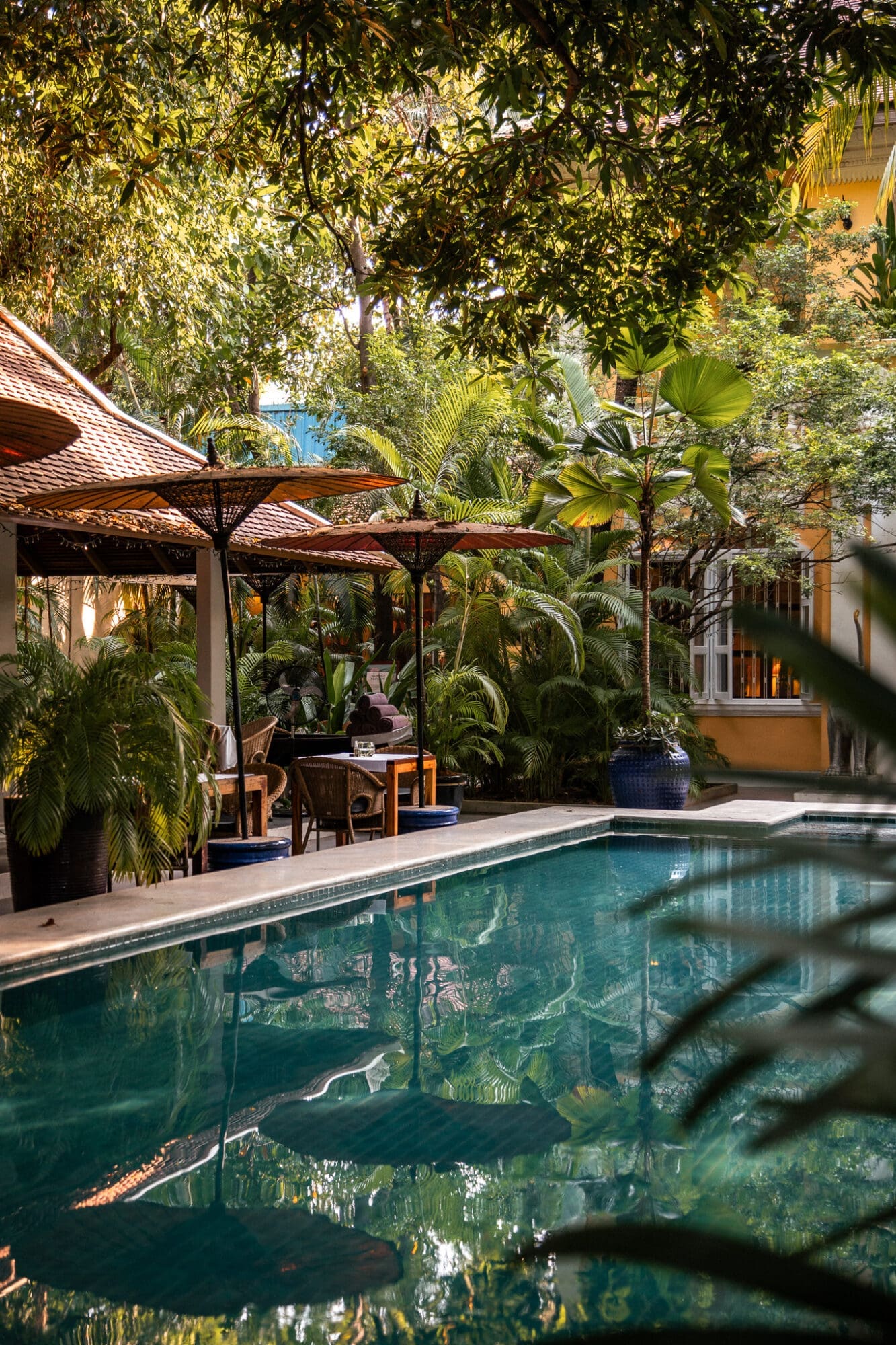 Lush pool with umbrella reflections at The Pavilion Phnom Penh Cambodia