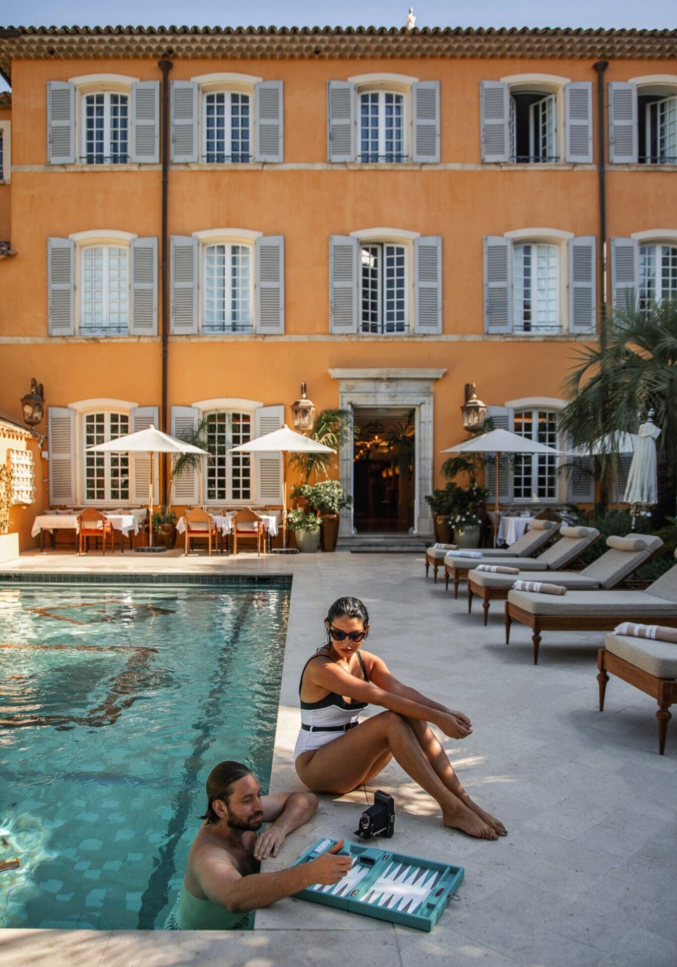 Anoushka and Adam playing a game of backgammon by the pool at Airelles Saint Tropez