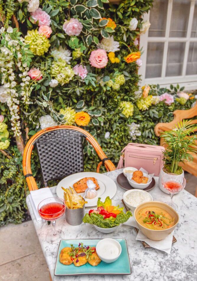A Picture of a table at Dalloway Terrace in London Fitzrovia with food against and Instagrammable Backdrop